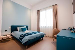a bedroom with a blue bed and a window at La Corte del Fante in Marsala