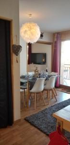 une salle à manger avec une table et des chaises blanches dans l'établissement Au Centre de la station de ski de Valfréjus - appartement 4-6 personnes, à Valfréjus