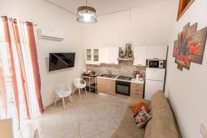a living room with a couch and a kitchen at Residenza Giuseppina in Syracuse