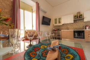 a living room with a glass table with wine glasses at Residenza Giuseppina in Siracusa