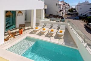 a house with a swimming pool and chairs and a house at Casa do Pátio-Two Private Pools Villa- Rooftop & Panoramic Pool in Albufeira