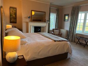 a bedroom with a large bed and a fireplace at Yearle House in Wooler