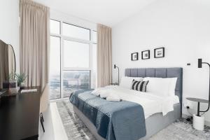 Un dormitorio blanco con una cama grande y una ventana en Ultimate Stay / 3 Beds / Gorgeous Frame and Park View / 250m from Metro / 1 Stop from World Trade Center, en Dubái