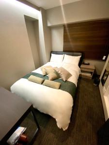 a bedroom with a large bed with white sheets and pillows at Hotel Prezier Akihabara - Vacation STAY 21812v in Tokyo