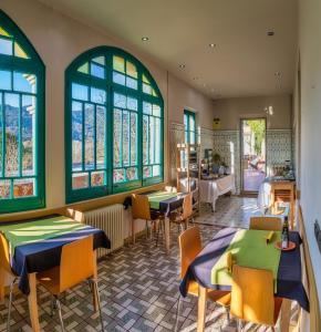 un restaurante con mesas, sillas y ventanas en Els Jardins De La Martana, en Besalú