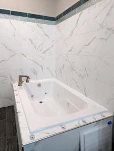 y baño con bañera blanca y paredes de mármol. en Wingate by Wyndham Biloxi - Ocean Springs, en Biloxi