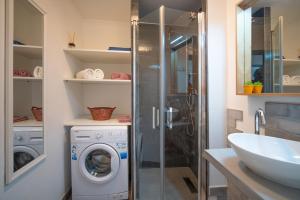 Un baño con lavadora y lavabo. en Apartman Zara, en Matulji