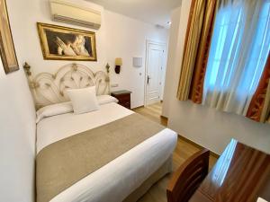 A bed or beds in a room at Hostal Rodri
