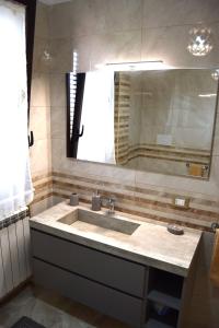 bagno con lavandino e grande specchio di Casa D'Amico ad Arnesano