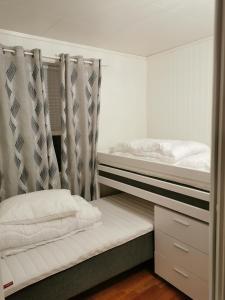 a bedroom with two bunk beds with curtains at NyksundRom, Nyksund in Nyksund