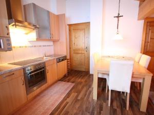 a kitchen with a table and a sink and a stove at Villa on a courtyard near the ski area in Salzburg in Eben im Pongau