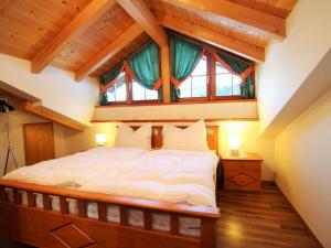 ein Schlafzimmer mit einem großen Bett und einem großen Fenster in der Unterkunft Villa on a courtyard near the ski area in Salzburg in Eben im Pongau