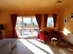 uma sala de estar com cadeiras vermelhas e uma grande janela em Chalet in Hohentauern Styria near ski area em Hohentauern