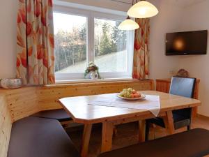 a dining room with a wooden table and a window at Spacious Apartment with Sauna in F gen in Fügen