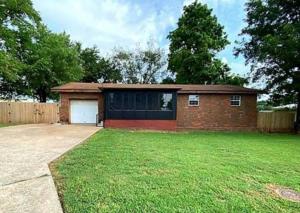 a brick house with a garage in a yard at The Greenhouse - 3bed 2bath home in Tahlequah, OK in Tahlequah