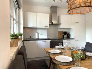 a kitchen with white cabinets and a table with chairs at Beautiful apartment with terrace in Feuring