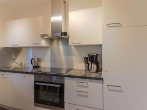 a kitchen with white cabinets and a stove top oven at Beautiful apartment with terrace in Feuring