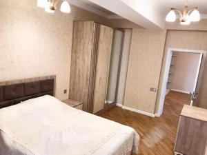 ein Schlafzimmer mit einem weißen Bett und einem Schrank in der Unterkunft Family Apartment in Baku