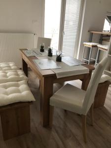 a wooden table with a white chair and a wooden table at Garden House in Kranj