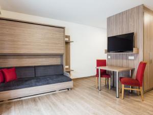 クライナルにあるStriking Apartment in Kleinarl with Ski Storage Parking Balconyのベッド、テーブル、テレビが備わる客室です。