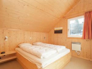 a bed in a wooden room with a window at Chalet in Stadl an der Mur with sauna in Stadl an der Mur