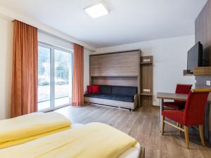 クライナルにあるStriking Apartment in Kleinarl with Ski Storage Parking Balconyのベッド、デスク、テーブルが備わる客室です。