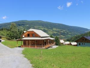 ein großes Holzhaus auf einem Feld neben einer Straße in der Unterkunft Chalet in Stadl an der Mur with sauna in Stadl an der Mur