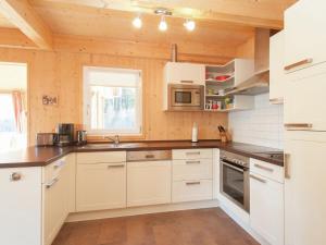 a kitchen with white cabinets and a counter top at Chalet in Stadl an der Mur with sauna in Stadl an der Mur