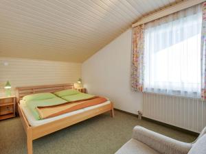 a bedroom with a bed and a chair and a window at Spacious Apartment in Afritz am See near Ski Area in Afritz