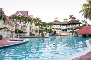 einen Pool in einem Resort mit Palmen und Gebäuden in der Unterkunft E 20 Mystic Ridge ocho Rios in Ocho Rios