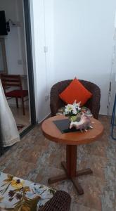 a table in a room with a chair and a table with a vase on at johnny's studio in Grand-Baie