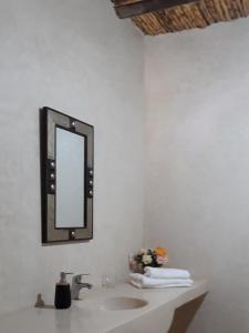 baño con lavabo y espejo en la pared en Ourika Timalizène le jardin des délices en Tamzerdirt