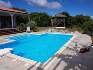 a swimming pool in a yard with a gazebo at Villa Maria'Landa in Capesterre