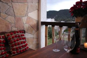 a table with two wine glasses and a bottle of wine at Hotel Na´Lum in San Cristóbal de Las Casas