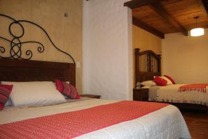 a bedroom with two beds in a room at Hotel Na´Lum in San Cristóbal de Las Casas