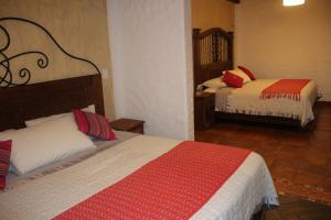 a hotel room with two beds in a room at Hotel Na´Lum in San Cristóbal de Las Casas