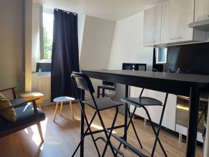 uma cozinha com mesa e cadeiras num quarto em Appartement neuf et chaleureux dans Leers centre em Leers