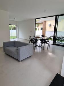 sala de estar con sofá, mesas y sillas en Casa 17 Lençóis Maranhenses - Barreirinhas - MA en Barreirinhas