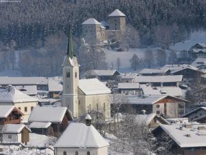 a small town covered in snow with a church at Apartment in Kaprun with Ski-in Ski-out Access in Kaprun