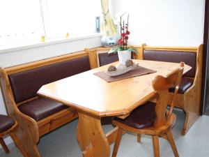 a dining room table with chairs and a wooden table at Lovely Chalet in Maria Alm with Terrace in Maria Alm am Steinernen Meer