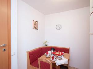 einen kleinen Tisch in einem Zimmer mit einem roten Stuhl in der Unterkunft Apartment in Altenmarkt in Pongau near ski area in Altenmarkt im Pongau