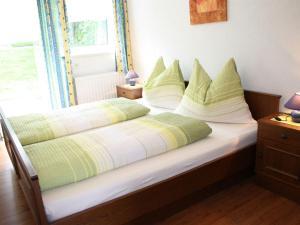 a bedroom with two beds with green and white pillows at Lovely Chalet in Maria Alm with Terrace in Maria Alm am Steinernen Meer