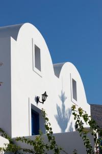 a white building with a blue sky in the background at Veggera Beach Hotel in Perissa