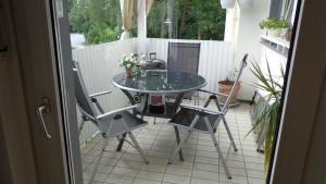 a glass table and two chairs on a patio at Ferienwohnung LAN in Bad Rothenfelde