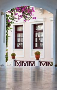 a white building with two windows and flowers at Veggera Beach Hotel in Perissa