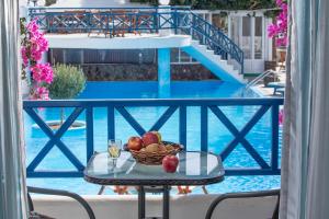 a bowl of fruit on a table next to a pool at Veggera Beach Hotel in Perissa