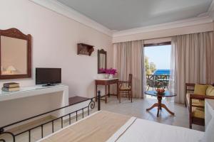 a hotel room with a bed and a living room at Veggera Beach Hotel in Perissa