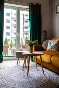 a living room with a couch and a coffee table at Apartament Panorama De Lux Family in Koszalin