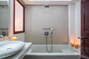 a bathroom with a shower with a tub and a sink at Veggera Beach Hotel in Perissa