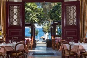 a restaurant with tables and chairs and a view of the ocean at Veggera Beach Hotel in Perissa